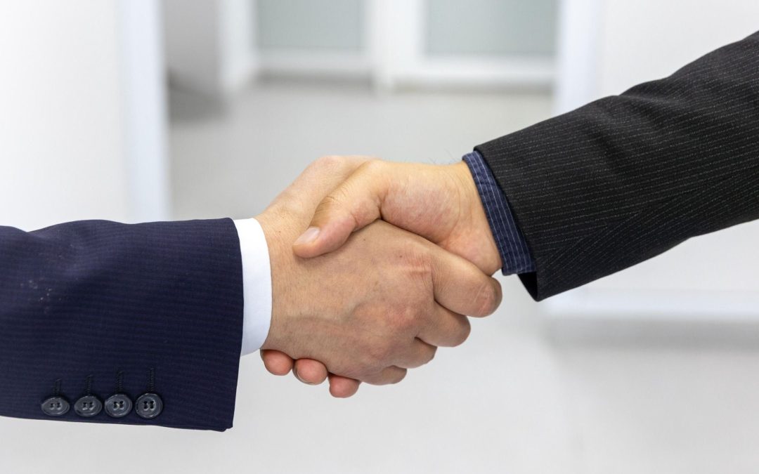 Dos profesionales estrechando la mano como símbolo de acuerdo de colaboración empresarial.