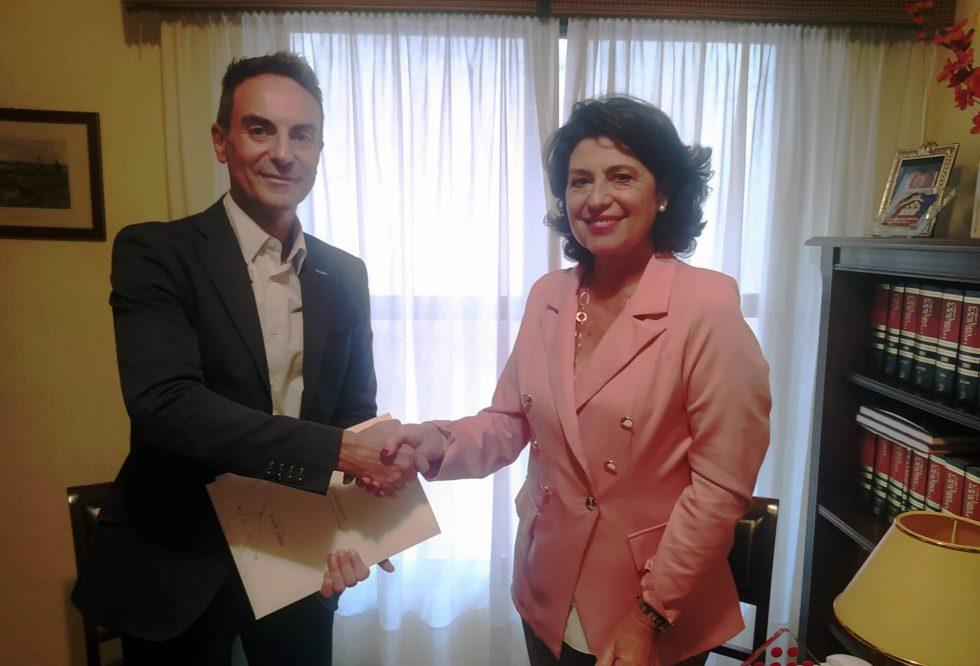 Representantes de CAF Córdoba y Conversia estrechando la mano tras la firma de un acuerdo de colaboración.