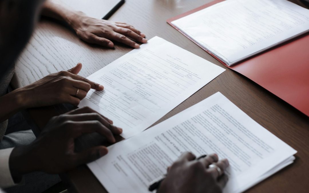 Personas firmando documentación durante una reunión profesional relacionada con un acuerdo de colaboración empresarial.