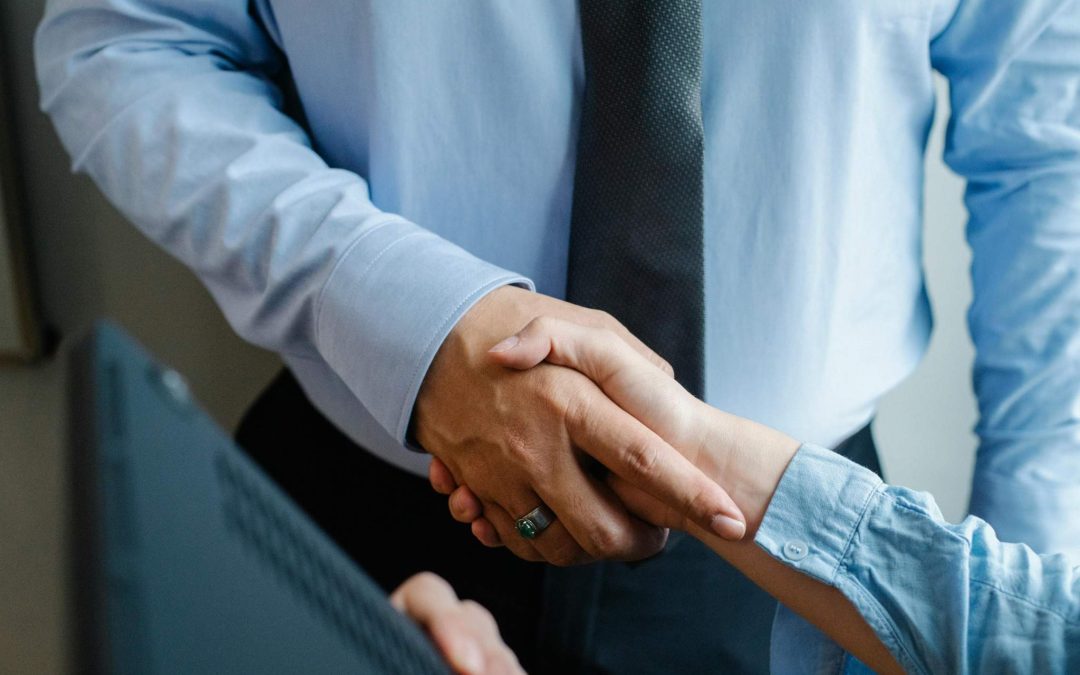Representantes empresariales estrechando la mano durante la firma de un acuerdo de colaboración profesional.